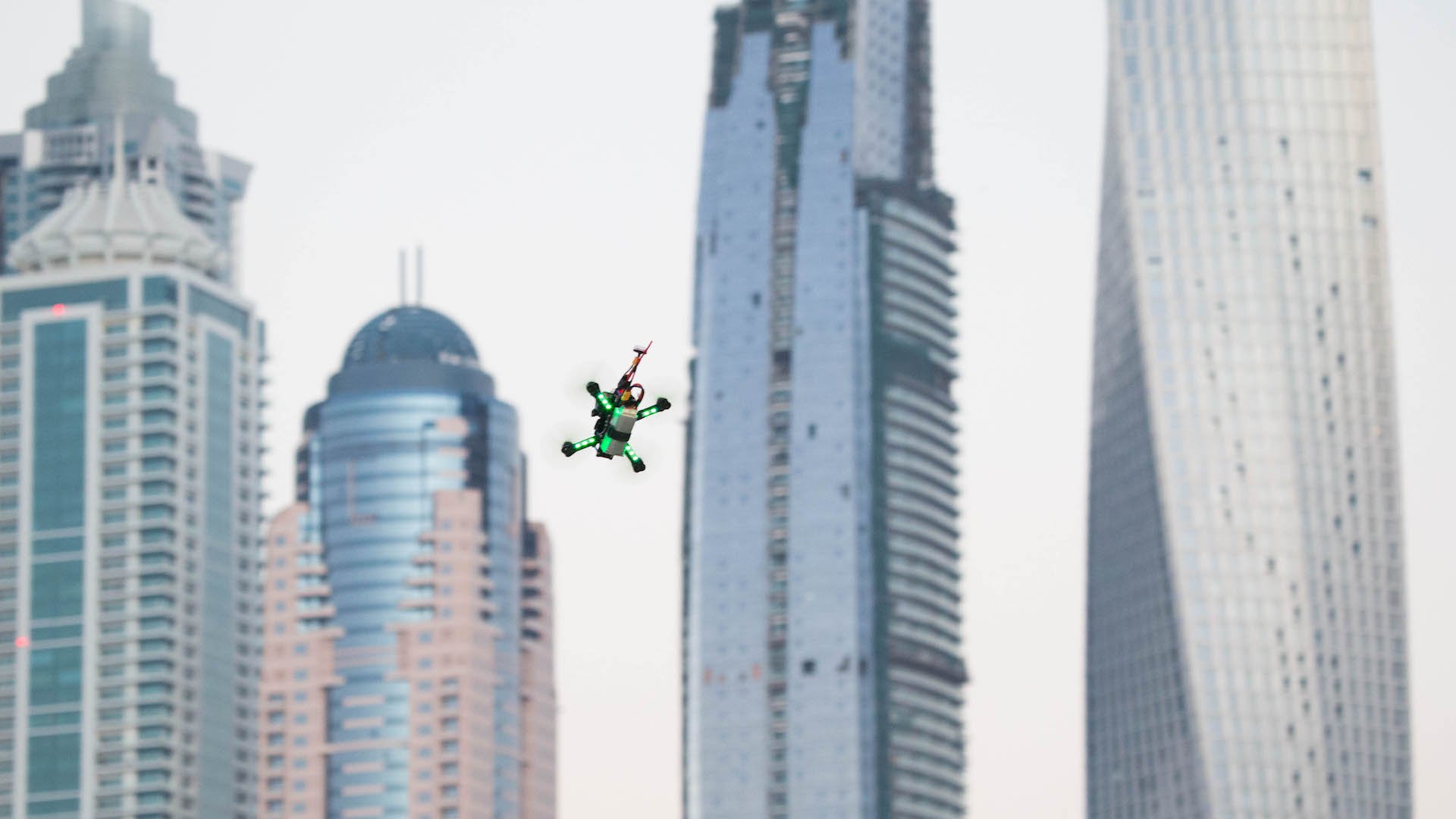 A drone flies around the track in front of the Dubai's Marina skyline during the World Drone Prix drone racing championship in Dubai, United Arab Emirates, on Saturday, March 12, 2016. Teams compete for the global champion purse of total prizes of $1 million by navigating drones at over 100kms an hour around a track which features multiple pathways, kinetic and static obstacles designed to push pilots to their limits. Photographer: Razan Alzayani/Bloomberg