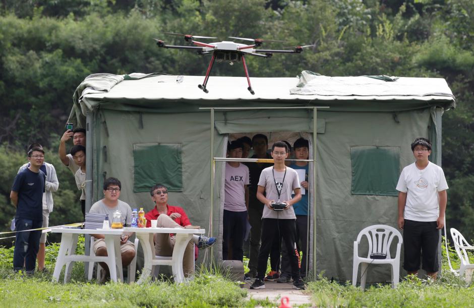 A trainee flies a drone next to a China Civil UAS (Unmanned Aerospace Surveillance) Pilot Flight examiner (in red) during his examination for the license from AOPA CHINA (Aircraft Owners and Pilots Association) at LTFY drone training school on the outskirts of Beijing, China August 14, 2017. REUTERS/Jason Lee