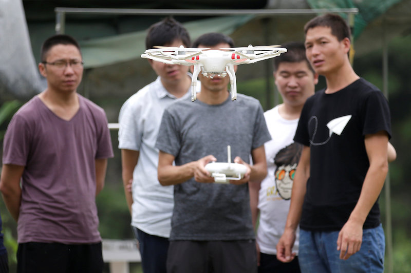 A trainee learns to fly a DJI drone next to the instructor at LTFY drone training school on the outskirts of Beijing