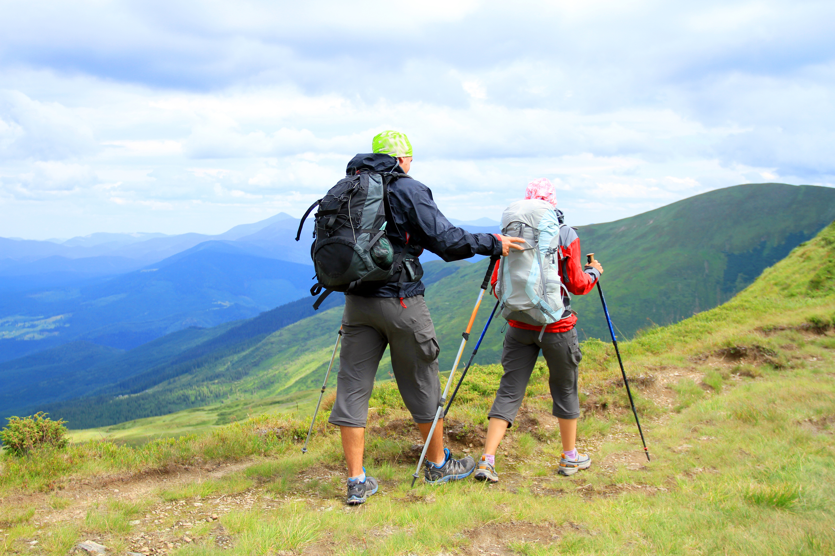 Summer hiking in the mountains.Hikers - people hiking, man looking at mountain nature landscape scenic with woman in background.